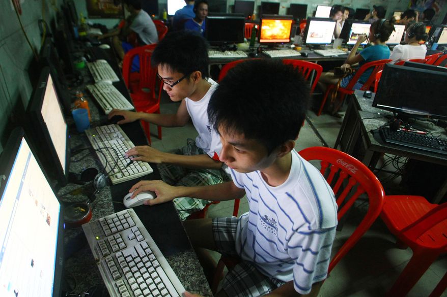 In this Sept. 27, 2012, file photo, two students use computers at an internet cafe near their dormitory in Hanoi, Vietnam. Amnesty International has found that a hacking group known as Ocean Lotus has been staging more spyware attacks on Vietnamese human rights activists in the latest blow to freedom of speech in the communist-ruled country. AP Photo/Na Son Nguyen, File)