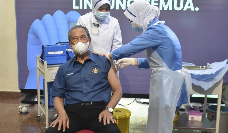 Malaysia&#39;s Prime Minister Muhyiddin Yassin receives the first dose of the Pfizer-BioNTech COVID-19 vaccine at a clinic in Putrajaya, Malaysia, Wednesday, Feb. 24, 2021. (Malaysia Health Ministry via AP)