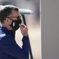 Chicago White Sox general manager Rick Hahn adjusts his face covering as he watches players during baseball spring training Wednesday, Feb. 24, 2021, in Phoenix. (AP Photo/Ross D. Franklin)