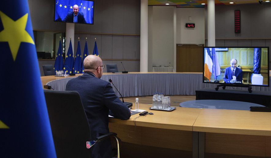 European Council President Charles Michel speaks with Ireland&#39;s Prime Minister Micheal Martin, on screen right, via videoconference at the European Council building in Brussels, Wednesday, Feb. 24, 2021. (AP Photo/Olivier Matthys, Pool)
