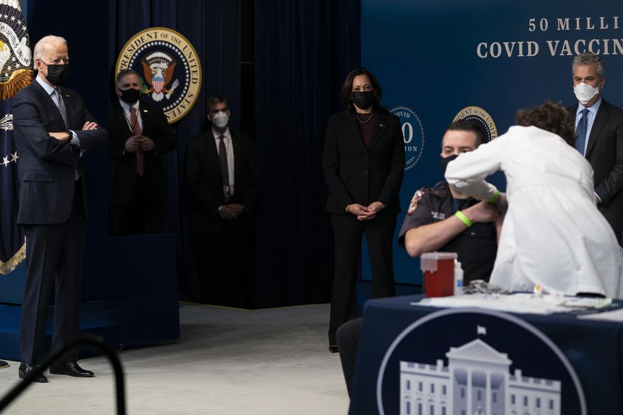 President Joe Biden looks on as DC firefighter and EMT Corey Hamilton receives a vaccination, during an event to commemorate the 50 millionth COVID-19 shot, in the South Court Auditorium on the White House campus, Thursday, Feb. 25, 2021, in Washington. Vice President Kamala Harris and White House COVID-19 Response Coordinator Jeff Zients look on. (AP Photo/Evan Vucci) **FILE**