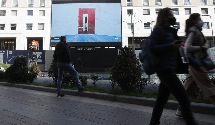 A giant screen streams a Prada fashion live show during the women's Fall Winter 2021-22 collection, unveiled during the Fashion Week in Milan, Italy, Thursday, Feb. 25, 2021. (AP Photo/Antonio Calanni)