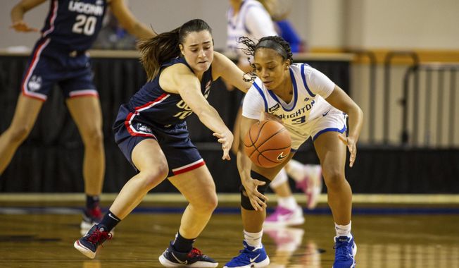 Connecticut guard Nika Muhl (10) knocks the ball away from Creighton guard DeArica Pryor (3) in the fourth quarter during an NCAA college basketball game Thursday, Feb. 25, 2021, in Omaha, Neb. (AP Photo/John Peterson)