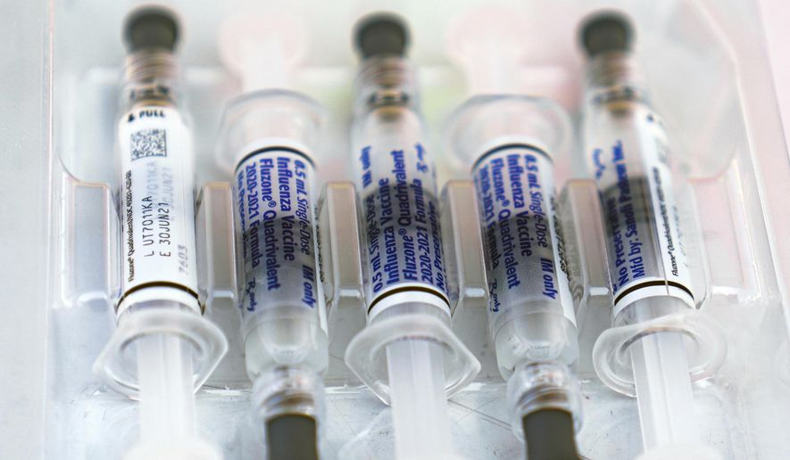 This Saturday, Oct. 17, 2020, file photo shows influenza vaccine syringes at the L.A. Care Health Plan and Blue Shield of California Promise Health Plan's Community Resource Center's Free Drive-Thru vaccination event in Los Angeles. February is usually the peak of flu season, with doctors' offices and hospitals packed with suffering patients. But not in 2021. Flu has virtually disappeared, with reports coming in at far lower levels than anything seen in decades. (AP Photo/Damian Dovarganes)