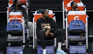 Brooklyn Nets DeAndre Jordan, left, Kevin Durant, center, and Kyrie Irving watch their teammates play the Sacramento King during the second half of an NBA basketball game in Sacramento, Calif., Monday, Feb. 15, 2021. Durant did not play due to an injury. The Nets won 136-125. (AP Photo/Rich Pedroncelli)