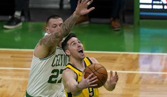 Indiana Pacers guard T.J. McConnell (9) goes to the hoop against Boston Celtics center Daniel Theis (27) in the first quarter of an NBA basketball game, Friday, Feb. 26, 2021, in Boston. (AP Photo/Elise Amendola)