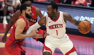 Houston Rockets guard John Wall (1) holds off Toronto Raptors guard Fred VanVleet (23) and forward Stanley Johnson (5) during the first half of an NBA basketball game Friday, Feb. 26, 2021, in Tampa, Fla. (AP Photo/Chris O&#39;Meara)