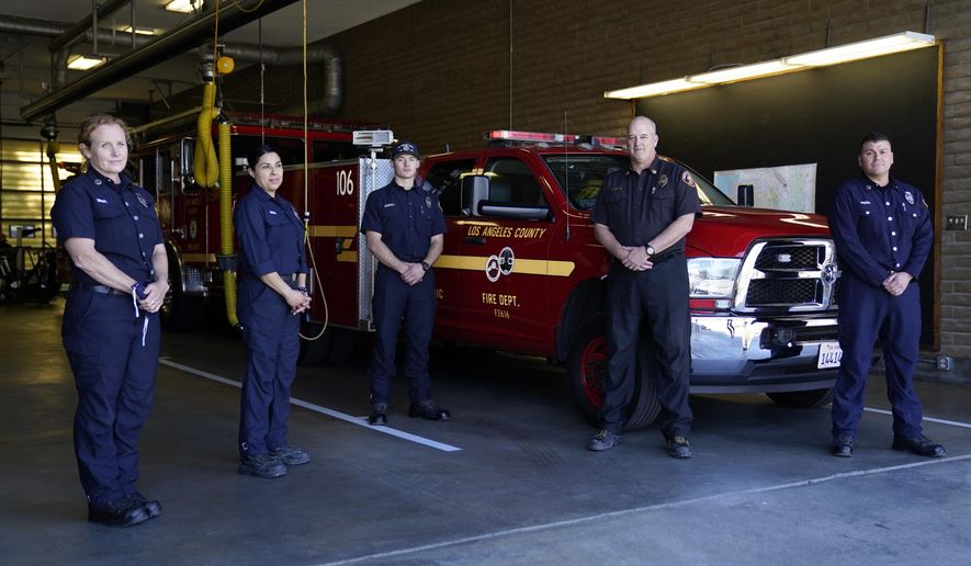 From left, fire Truck Captain Jeane Barrett, firefighter paramedic Sally Ortega, engine probationary firefighter Cole Gomoll, Battalion Chief Dean Douty, and Engine Captain Joe Peña, all first responders from Los Angeles County Fire Department - Station 106, pose for a photo at their station Friday, Feb. 26, 2021, in Rancho Palos Verdes, Calif, a suburb of Los Angeles. The crew responded to the scene of a vehicle crash involving golfer Tiger Woods on Tuesday. (AP Photo/Ashley Landis)