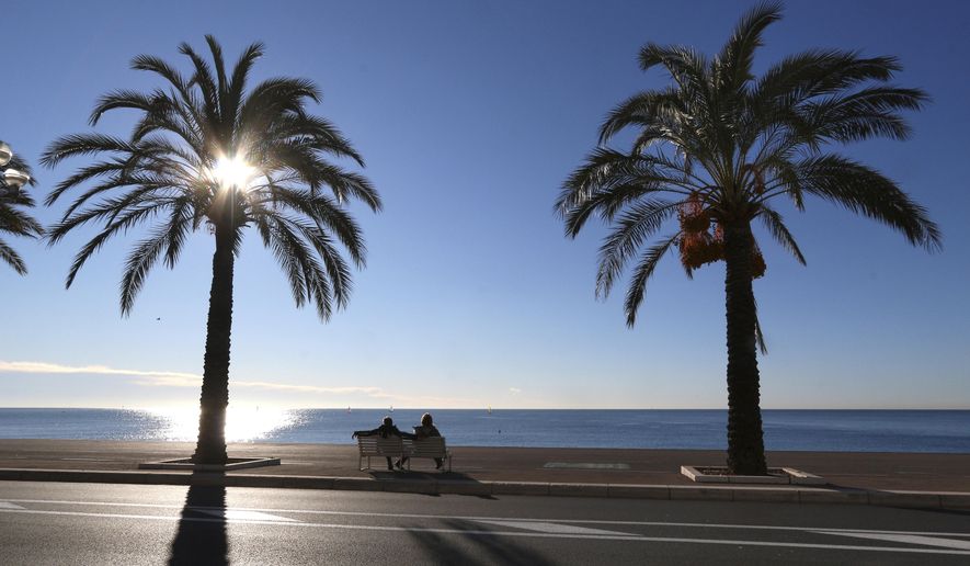 FILE - In this Jan. 16, 2016 file photo people take rest on the Promenade des Anglais, in Nice, southeastern France. Residents of the French Riviera city of Nice won't be allowed to enjoy a walk on the beach on a sunny weekend after authorities have decided to implement a local, temporary lockdown to try to curb the spread of the virus. (AP Photo/Lionel Cironneau, File)