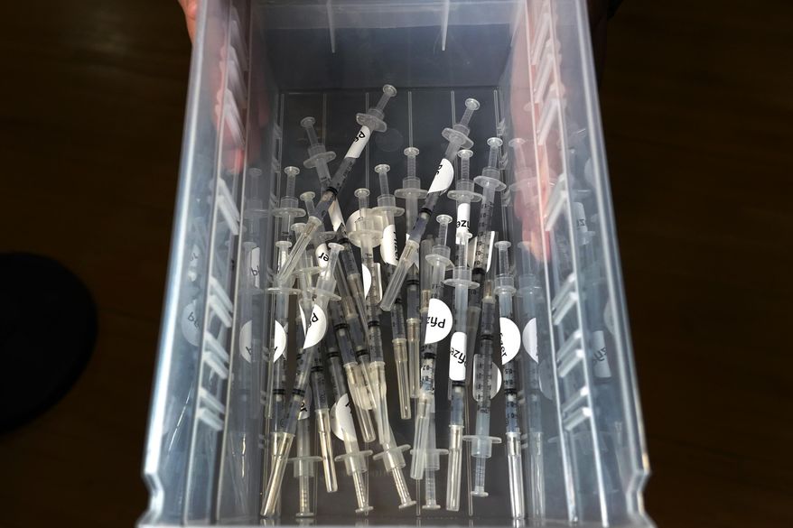 A nurse carries a tray of Pfizer's COVID-19 vaccines ready for recipients, Thursday, Feb. 25, 2021, at Lawrence General Hospital's vaccination site in Lawrence, Mass. (AP Photo/Elise Amendola)