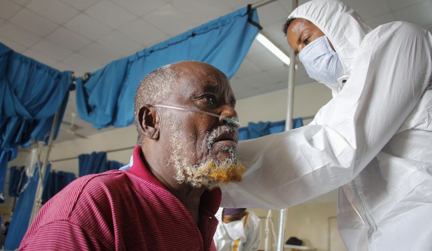 A doctor tends to a patient suffering from COVID-19 in a ward for coronavirus patients at the Martini hospital in Mogadishu, Somalia Wednesday, Feb. 24, 2021. (AP Photo/Farah Abdi Warsameh)