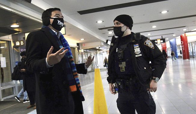 New York mayoral candidate Andrew Yang, left, talks to a New York City Police officer following an incident where Yang intervened as a photographer was attacked on the Staten Island Ferry, Friday, Feb. 26, 2021, in New York. (Paul Liotta/Staten Island Advance via AP)