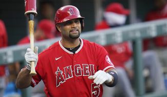 FILE - In this Sept. 12, 2020, file photo, Los Angeles Angels designated hitter Albert Pujols waves to players in the Colorado Rockies dugout in the second inning of a baseball game in Denver. Pujols’ wife apparently disclosed that the Angels slugger will retire after the upcoming season, although she later amended her social media post to be less definitive. (AP Photo/David Zalubowski, File)