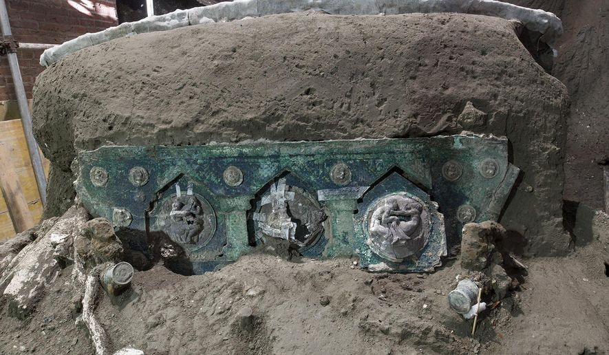 A view of a chariot, with its iron elements, bronze decorations and mineralized wooden remains, that was found in Civita Giuliana, north of Pompeii. Officials at the Pompeii archaeological site near Naples on Saturday, Feb. 27, 2021, announced the first-ever discovery of an intact ceremonial chariot, one of several important discoveries made in the same area outside the park following an investigation into an illegal dig. (Parco Archeologico di Pompei via AP)