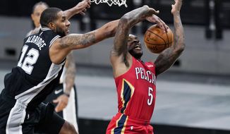 New Orleans Pelicans guard Eric Bledsoe (5) is blocked by San Antonio Spurs center LaMarcus Aldridge (12) as he tries to score during the first half of an NBA basketball game in San Antonio, Saturday, Feb. 27, 2021. (AP Photo/Eric Gay)