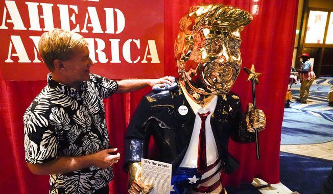 Sculptor Tommy Zegan, polishes his statue of former president Donald Trump on display at the Conservative Political Action Conference (CPAC) Friday, Feb. 26, 2021, in Orlando, Fla. Zegan says he has to wipe finger prints off the statue every hour or so. (AP Photo/John Raoux)