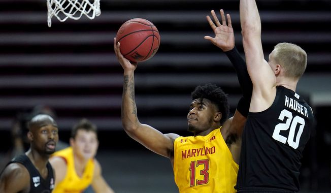 Maryland guard Hakim Hart (13) goes up for a shot against Michigan State forward Joey Hauser (20) during the first half of an NCAA college basketball game, Sunday, Feb. 28, 2021, in College Park, Md. (AP Photo/Julio Cortez)
