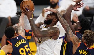 Los Angeles Lakers forward LeBron James, second from left, is fouled by Golden State Warriors guard Kelly Oubre Jr., right, while shooting as forward Juan Toscano-Anderson, left, and guard Jordan Poole defend during the first half of an NBA basketball game Sunday, Feb. 28, 2021, in Los Angeles. (AP Photo/Mark J. Terrill)