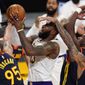 Los Angeles Lakers forward LeBron James, second from left, is fouled by Golden State Warriors guard Kelly Oubre Jr., right, while shooting as forward Juan Toscano-Anderson, left, and guard Jordan Poole defend during the first half of an NBA basketball game Sunday, Feb. 28, 2021, in Los Angeles. (AP Photo/Mark J. Terrill)