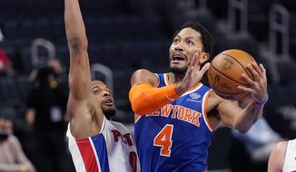 New York Knicks guard Derrick Rose (4) attempts a layup as Detroit Pistons guard Dennis Smith Jr. (0) defends during the first half of an NBA basketball game, Sunday, Feb. 28, 2021, in Detroit. (AP Photo/Carlos Osorio)