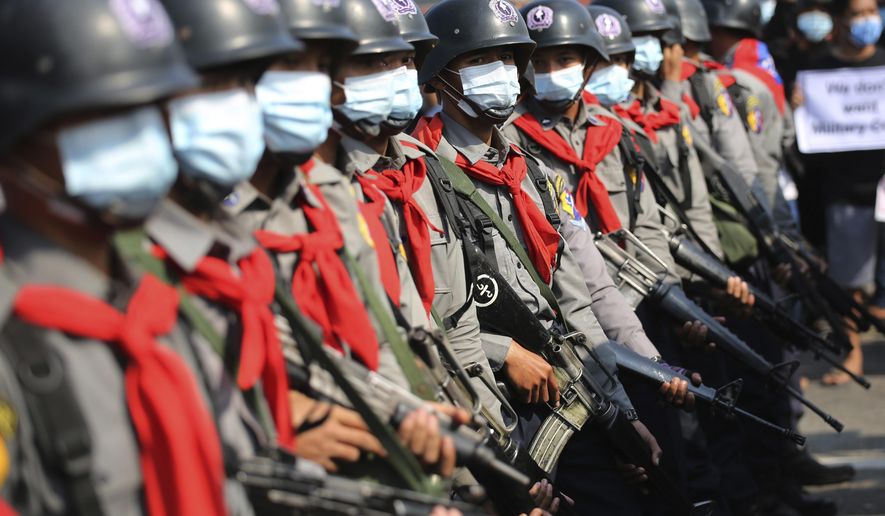 Armed riot police are seen near protesters in Naypyitaw, Myanmar, Monday, Feb. 8, 2021. In the month since Feb. 1 coup, the mass protests occurring each day are a sharp reminder of the long and bloody struggle for democracy in a country where the military ruled directly for more than five decades. (AP Photo)