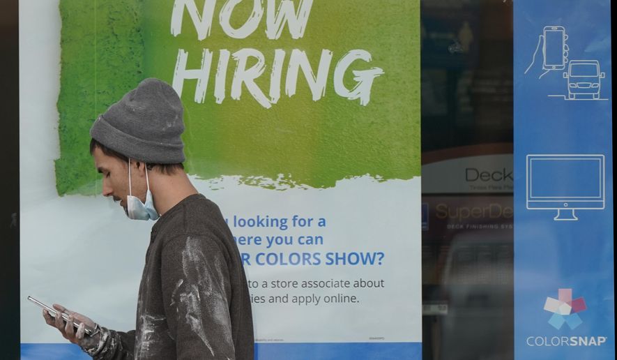 A man walks past a "Now Hiring" sign on a window at Sherwin Williams store, Friday, Feb. 26, 2021, in Woodmere Village, Ohio. Massive fraud in the nation's unemployment system is raising alarms even as President Joe Biden and Congress prepare to pour hundreds of billions more into expanded benefits for those left jobless by the coronavirus pandemic. (AP Photo/Tony Dejak)