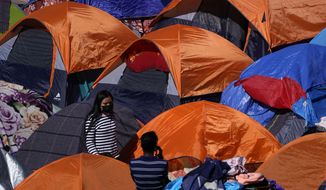 Tents used by migrants seeking asylum in the United States line an entrance to the border crossing, Monday, March 1, 2021, in Tijuana, Mexico. President Joe Biden is holding a virtual meeting with Mexican President Andrés Manuel López Obrador. Monday&#39;s meeting was a chance for them to discuss migration, among other issues. (AP Photo/Gregory Bull)