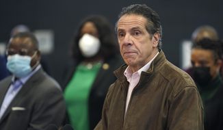 In this Feb. 22, 2021, photo, New York Gov. Andrew Cuomo, right, pauses to listen to a reporter&#39;s question during a news conference at a COVID-19 vaccination site in the Brooklyn borough of New York. New York&#39;s attorney general said she&#39;s moving forward with an investigation into sexual harassment allegations against the governor after receiving a letter from his office Monday authorizing her to take charge of the probe. (AP Photo/Seth Wenig, Pool, file)