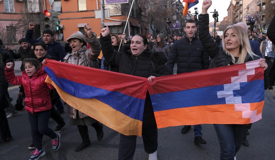 Opposition demonstrators carrying Armenian national and the separatist region of Nagorno-Karabakh’s flag, right, march to the government buildings during a rally to pressure Armenian Prime Minister Nikol Pashinyan to resign in Yerevan, Armenia, Saturday, Feb. 27, 2021. The developments come after months of protests sparked by the nation&#x27;s defeat in the Nagorno-Karabakh conflict with Azerbaijan. (Hrant Khachatryan/PAN Photo via AP)