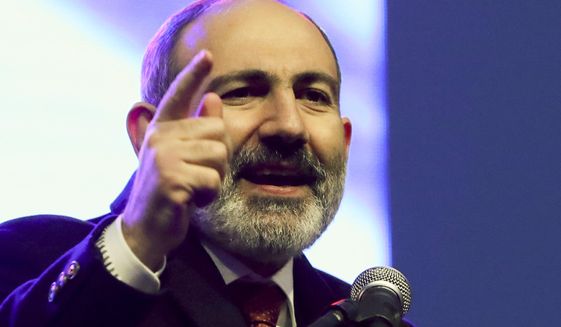 Armenian Prime Minister Nikol Pashinyan gestures while addressing his supporters during a rally in his support in the center of Yerevan, Armenia, Monday, March 1, 2021. Amid escalating political tensions in Armenia, supporters of the country&#39;s embattled prime minister and the opposition are staging massive rival rallies in the capital of Yerevan. Prime Minister Nikol Pashinyan has faced opposition demands to resign since he signed a peace deal in November that ended six weeks of intense fighting with Azerbaijan over the Nagorno-Karabakh region. (Hayk Baghdasaryan/PHOTOLURE via AP)