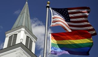 FILE - In this April 19, 2019 file photo, a gay pride rainbow flag flies along with the U.S. flag in front of the Asbury United Methodist Church in Prairie Village, Kan. Conservative leaders within the United Methodist Church unveiled plans Monday, March 1, 2021 to form a new denomination, the Global Methodist Church, with a doctrine that does not recognize same-sex marriage. The move could hasten the long-expected breakup of the UMC, America’s largest mainline Protestant denomination, over differing approaches to LGBTQ inclusion. (AP Photo/Charlie Riedel, File)