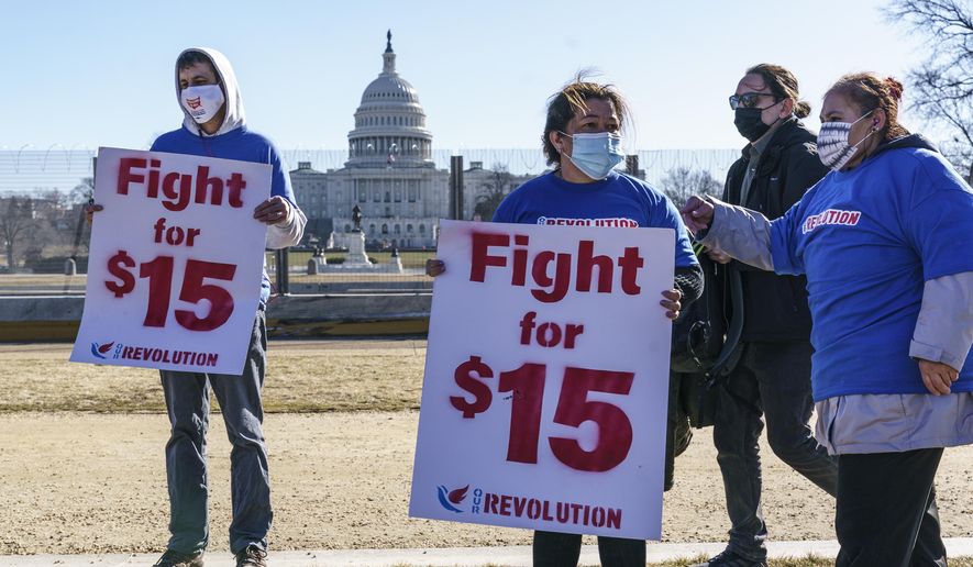Activists appeal for a $15 minimum wage near the Capitol in Washington on Thursday, Feb. 25, 2021. The $1.9 trillion COVID-19 relief bill being prepped in Congress includes a provision that over five years would hike the federal minimum wage to $15 an hour. (AP Photo/J. Scott Applewhite) **FILE**