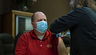 FILE - In this Feb. 3, 2021, file photo, a Tyson Foods team member receives a COVID-19 vaccine at meatpacking plant in Wilkesboro, N.C. Meatpacking workers have started receiving coronavirus vaccines and thousands more will have a chance to get their first shots this week, offering some peace of mind in an industry that was ravaged by COVID-19 a year ago. (Melissa Melvin/AP Images for Tyson Foods, File)