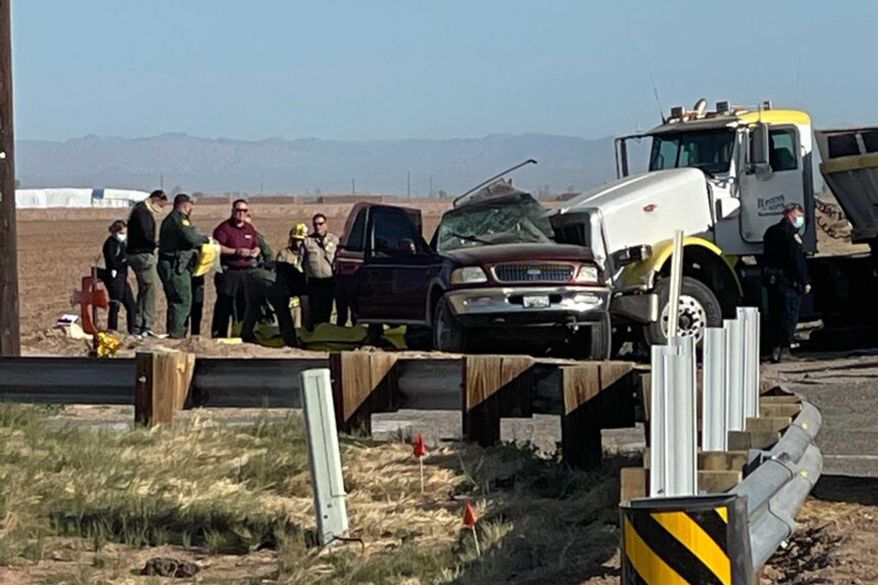 In this image from KYMA, law enforcement work at the scene of a deadly crash involving a semitruck and an SUV in Holtville, Calif., on Tuesday, March 2, 2021. (KYMA via AP)