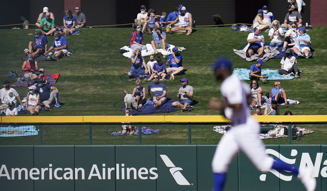 Socially distanced fans watch as Chicago Cubs right fielder Jason Heyward, foreground, head toward the dugout after the second inning of a spring baseball game against the Kansas City Royals in Mesa, Ariz., Tuesday, March 2, 2021. (AP Photo/Jae C. Hong)