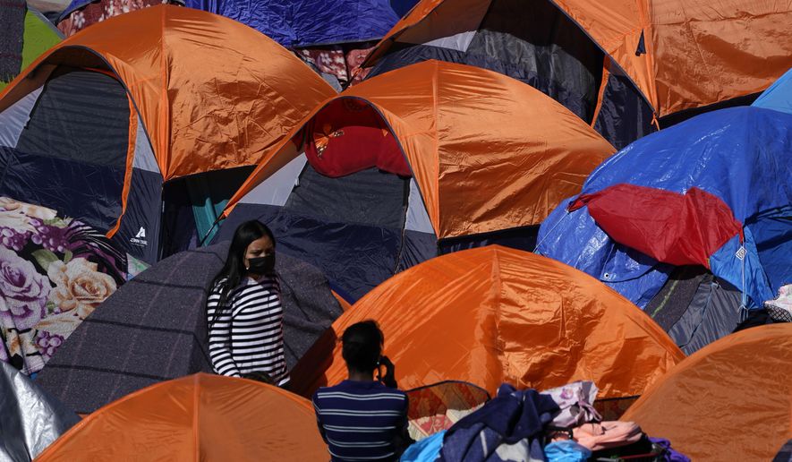 Tents used by migrants seeking asylum in the United States line an entrance to the border crossing, Monday, March 1, 2021, in Tijuana, Mexico. (AP Photo/Gregory Bull) ** FILE **
