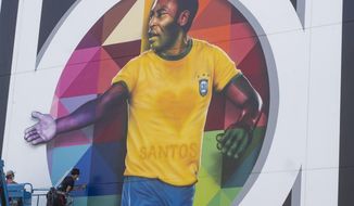 Brazilian street artist Eduardo Kobra spray paints the finishing touches to his mural to pay homage to soccer legend Pele to mark his 80th birthday in the coastal city of Santos, Brazil, Sunday, Oct. 18, 2020. Pele&#39;s birthday is Oct. 23. (AP Photo/Andre Penner)