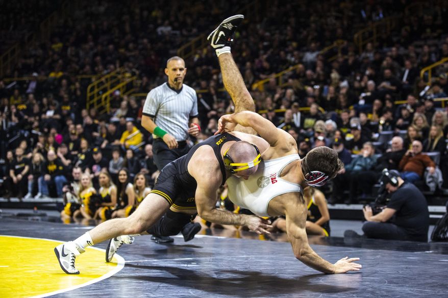 FILE - Iowa's Alex Marinelli, left, wrestles Ohio State's Ethan Smith at 165 pounds during a NCAA Big Ten Conference wrestling dual in Iowa City, Iowa, in this Friday, Jan. 24, 2020, file photo. The interruption to the season led to the cancellations of two duals, meaning the top-ranked Hawkeyes will go into the Big Ten championships having not competed since Feb. 7. The meet is Saturday and Sunday in State College, Pennsylvania. The Hawks won last year’s conference title and Marinelli, 125-pounder Spencer Lee and 149-pounder Pat Lugo took individual championships.(Iowa City Press-Citizen via AP, File)