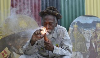FILE - In this Aug. 28, 2014 file photo, legalization advocate and reggae legend Bunny Wailer smokes a pipe stuffed with marijuana during a &amp;quot;reasoning&amp;quot; session in a yard in Kingston, Jamaica. Wailer, a reggae luminary who was the last surviving member of the legendary group The Wailers, died on Tuesday, March 2, 2021, in his native Jamaica, according to his manager. He was 73. (AP Photo/David McFadden, File)