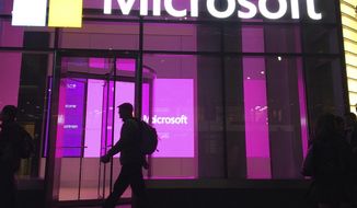 FILE - In this Nov. 10, 2016, file photo, people walk past a Microsoft office in New York. China-based government hackers have exploited a bug in Microsoft&#39;s email server software to target U.S. organizations, the company said Tuesday, March 2, 2021. (AP Photo/Swayne B. Hall, File)
