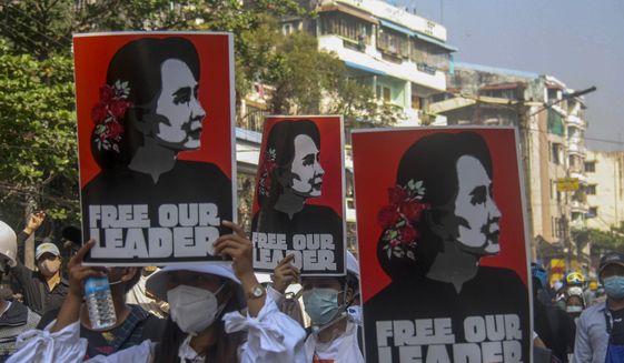Anti-coup protesters display pictures of deposed Myanmar leader Aung San Suu Kyi in Yangon, Myanmar, Tuesday, March 2, 2021. Police in Myanmar repeatedly used tear gas and rubber bullets Tuesday against crowds protesting last month&#39;s coup, but the demonstrators regrouped after each volley and tried to defend themselves with barricades as standoffs between protesters and security forces intensified. (AP Photo)