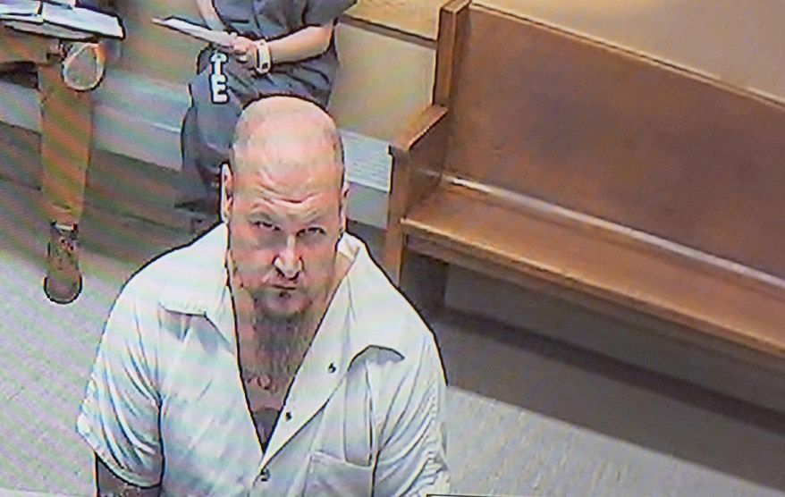 On a video monitor in a Spokane County Superior Court courtroom, Raymond Bryant, left, gives a not guilty plea during his arraignment to Judge Julie McKay, not pictured on lower right, on the charge of harassment stemming from racist graffiti found on Temple Beth Shalom, Tuesday, Mar. 2, 2021, in Spokane, Wash. (Jesse Tinsley/The Spokesman-Review via AP)