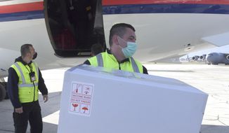 In this photo provided by the Serbian Presidential Press Service, a worker holds a box of the Astra-Zeneca vaccines at Sarajevo Airport, Bosnia, Tuesday, March 2. 2021. Bosnia on Tuesday received 10,000 vaccines from neighboring Serbia amid a dispute with the international COVAX mechanism over a delay in planned shipments. Serbia&#39;s populist President Aleksandar Vucic flew to the Bosnian capital of Sarajevo to deliver the Astra-Zeneca vaccines to the authorities there. (Serbian Presidential Press Service via AP)