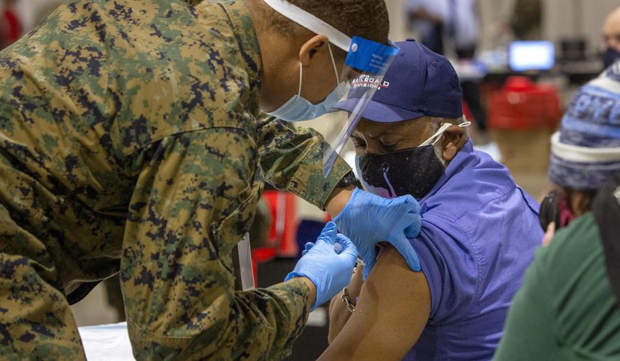 Garry E. Dean, SEPTA Regional Rail Station Manager, gets vaccinated by military personnel at the FEMA Community Vaccination Center in Center City Philadelphia on Tuesday, March 2, 2021. Secretary of Homeland Security Alejandro N. Mayorkas toured the FEMA Community Vaccination Center earlier in the day. (Alejandro A. Alvarez/The Philadelphia Inquirer via AP)