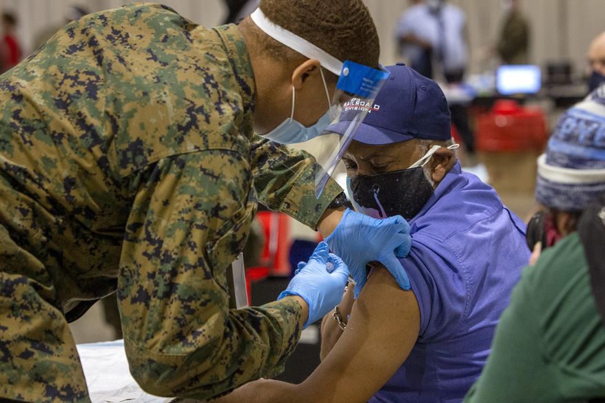 Garry E. Dean, SEPTA Regional Rail Station Manager, gets vaccinated by military personnel at the FEMA Community Vaccination Center in Center City Philadelphia on Tuesday, March 2, 2021. Secretary of Homeland Security Alejandro N. Mayorkas toured the FEMA Community Vaccination Center earlier in the day. (Alejandro A. Alvarez/The Philadelphia Inquirer via AP)
