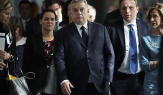 FILE - In this Wednesday, March 20, 2019 file photo, Hungarian Prime Minister Viktor Orban, center, arrives to a European People&#39;s Party&#39;s meeting at the European Parliament in Brussels. Hungary&#39;s governing party pulled out of its conservative group in the European Union&#39;s legislature on Wednesday, March 3, 2021 following years of conflict over the rule of law and European values. In a letter Wednesday to Manfred Weber, chairman of the EPP Group in the European Parliament, Hungarian Prime Minister Viktor Orban announced Fidesz&#39;s decision to leave the group. (AP Photo/Francisco Seco, File)