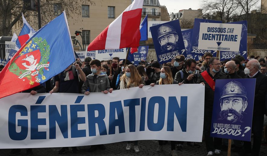 FILE - In this Feb.20, 2021 file photo, supporters of the group Generation Identity hold a banner reading "Man does not dissolve a generation" during a demonstration in Paris. French Interior Minister Gerald Darmanin announced Wednesday the dissolution of the anti-migrant group Generation Identity during a Cabinet meeting on the ground it is encouraging discrimination in the country. (AP Photo/Francois Mori, File)