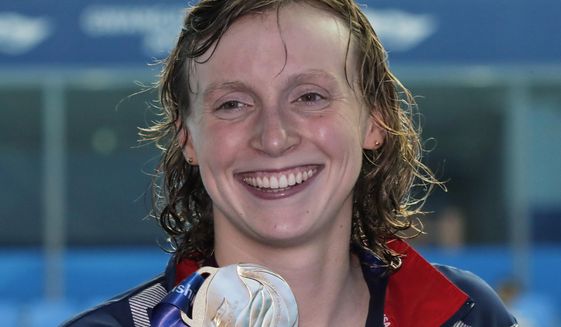 This July 27, 2019, file photo shows gold medalist United States&#39; Katie Ledecky posing with her medal following the women&#39;s 800m freestyle final at the World Swimming Championships in Gwangju, South Korea. Ledecky is a native of Bethesda, Md., a suburb of Washington, D.C. and among at least 40 D.C.-area swimmers are taking part in the Tokyo Olympics swimming trials, hopeful to go for the gold as part of Team USA. (AP Photo/Lee Jin-man, File) **FILE**