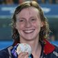 This July 27, 2019, file photo shows gold medalist United States&#39; Katie Ledecky posing with her medal following the women&#39;s 800m freestyle final at the World Swimming Championships in Gwangju, South Korea. Ledecky is a native of Bethesda, Md., a suburb of Washington, D.C. and among at least 40 D.C.-area swimmers are taking part in the Tokyo Olympics swimming trials, hopeful to go for the gold as part of Team USA. (AP Photo/Lee Jin-man, File) **FILE**