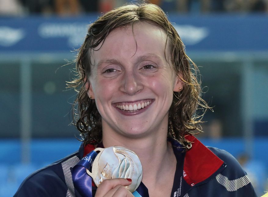 This July 27, 2019, file photo shows gold medalist United States&#x27; Katie Ledecky posing with her medal following the women&#x27;s 800m freestyle final at the World Swimming Championships in Gwangju, South Korea. Ledecky is a native of Bethesda, Md., a suburb of Washington, D.C. and among at least 40 D.C.-area swimmers are taking part in the Tokyo Olympics swimming trials, hopeful to go for the gold as part of Team USA. (AP Photo/Lee Jin-man, File) **FILE**